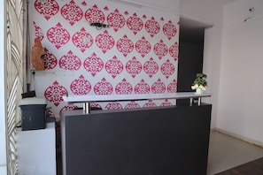 A reception desk with a patterned wall in the background.
