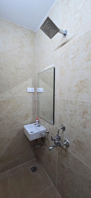 A bathroom with a shower, a sink, and a mirror.