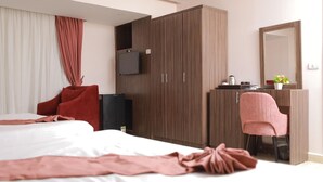 A hotel room with a bed, a desk, a chair, a wardrobe, a television, and a mirror. - Guest House Pyramids View (Giza)