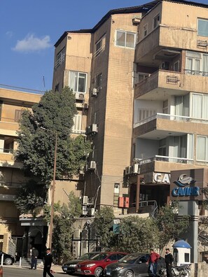 A multi-story building with balconies, air conditioning units, and a sign for 'CAVIA.' - Guest House Pyramids View (Giza)