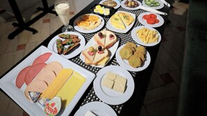 A dining table with various dishes, a glass of orange juice, and a bottle of water. - Guest House Pyramids View (Giza)