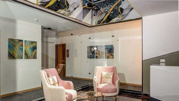 A modern lobby with marble flooring, two plush armchairs, and abstract art on the walls. - Guest House Pyramids View (Giza)