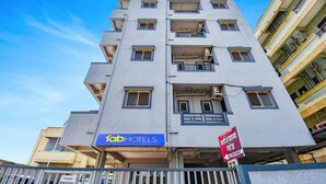 A multi-story hotel with a blue sign reading 'fab hotels.' - Fabhotel Ashiyana Lodge (Paud)