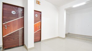 A hallway with two wooden doors marked with numbers 02 and 03, leading to rooms. - Fabhotel Ashiyana Lodge (Paud)
