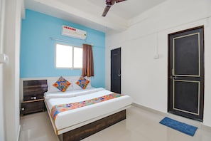 Un dormitorio con cama, ventana, aire acondicionado, puerta y un tapete azul.