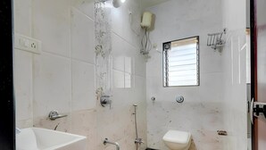 A bathroom with a sink, toilet, shower, and a window. - Hotel 7 Sea S Vagator (Vagator)