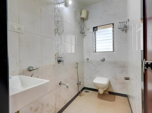A bathroom with a sink, toilet, shower, and a window. - Hotel 7 Sea S Vagator (Vagator)