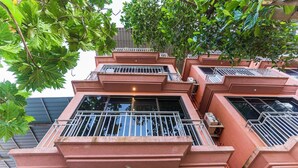 Un edificio de varios pisos con balcones, cada uno con barandillas de metal y un ventanal pequeño.