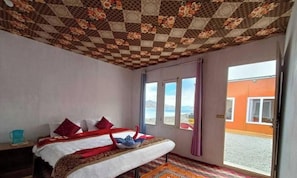 Habitación de hotel con cama, ventana y vistas al exterior.