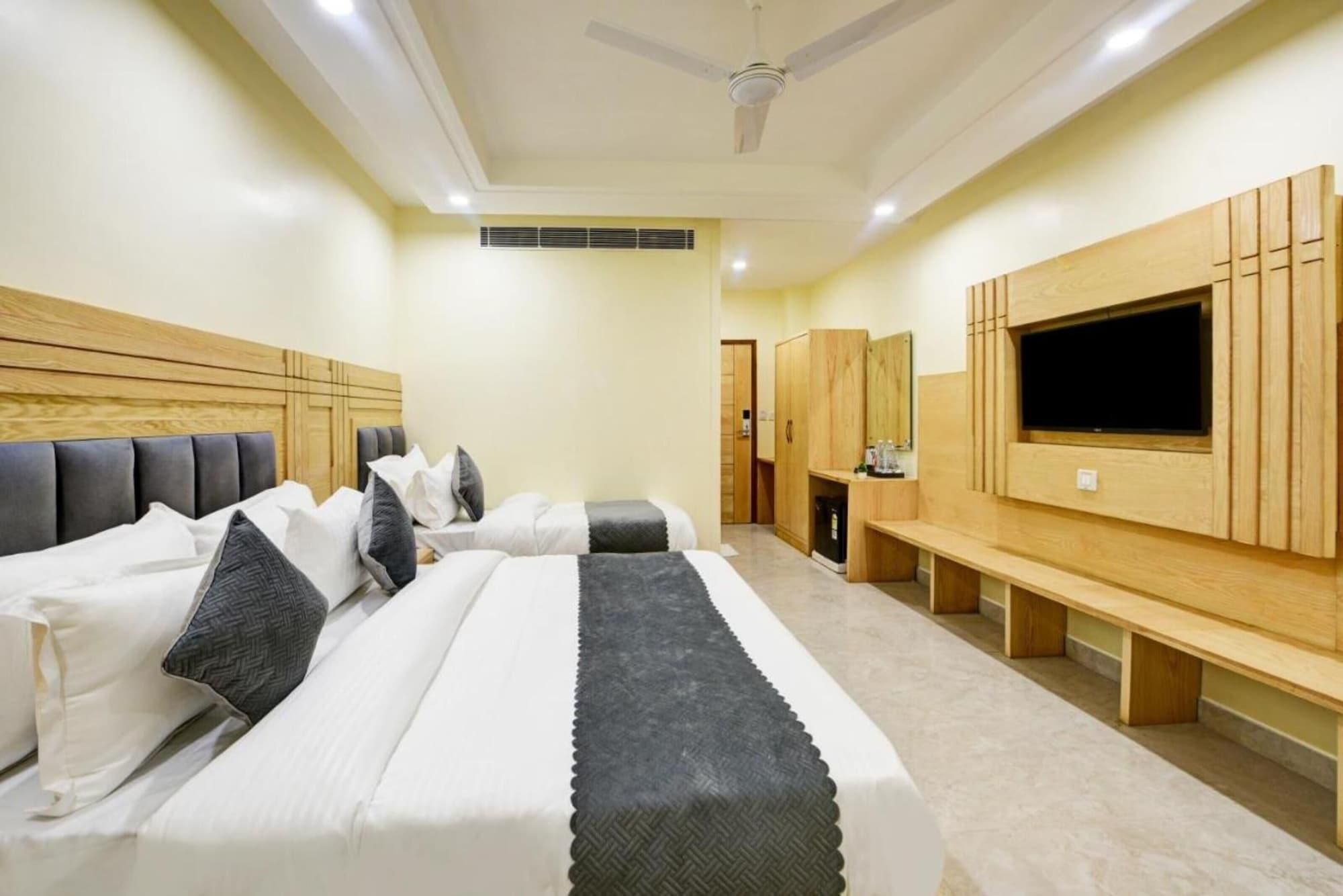 Ein Hotelzimmer mit Bett, Fernseher, Kleiderschrank und Deckenventilator.