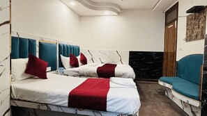 A hotel room with two beds, a blue chair, and marble walls. - Hotel Vin Inn New Delhi Railway Station (New Delhi)