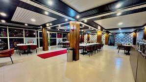 A spacious restaurant with high ceilings, large windows, and a modern interior design. - Ab S Abode A Boutique Hotel (Dehradun)
