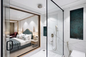 A modern hotel room with a glass-enclosed bed, a shower area, and marble walls. - Ab S Abode A Boutique Hotel (Dehradun)