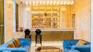 Eine luxuriöse Lobby mit Marmorwänden, einer zentralen Bar mit Glasvitrinen und blauen Sofas.