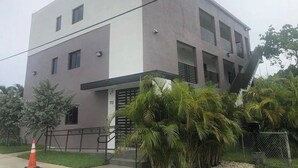 A modern two-story building with a flat roof, a balcony on the second floor, and a gated entrance. - Compact 1BR Retreat | close to Miami Beach (Miami)