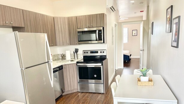 A compact kitchen with a refrigerator, microwave, oven, and dishwasher. - Compact 1BR Retreat | close to Miami Beach (Miami)