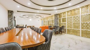 A conference room with a wooden table, grey upholstered chairs, and patterned wall panels. - Zinith Hotel (New Delhi)