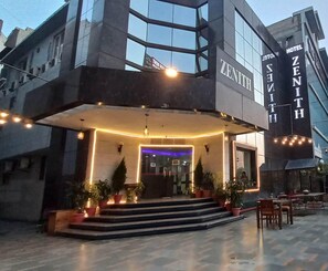 A hotel entrance with a modern design, featuring a large sign with the name 'ZENITH HOTEL' and a well-lit entrance area with steps leading up to the door. - Zinith Hotel (New Delhi)