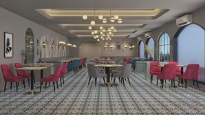 A restaurant with round tables, red and grey chairs, and patterned flooring. - Metropark Hotel (Mawal)