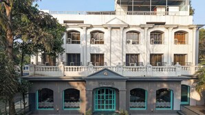 A two-story building with a central entrance, large windows, and a balcony on the upper floor. - Metropark Hotel (Mawal)
