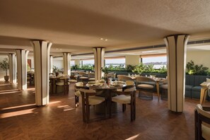 A spacious dining area with multiple tables and chairs, large pillars, and a view of the outdoors. - Soleil Nile Cruise (Cairo)