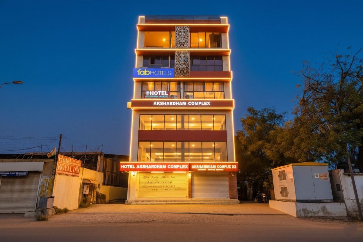 Un hotel de varios pisos con un cartel llamativo que dice 'Hotel Akshardham Complex'.