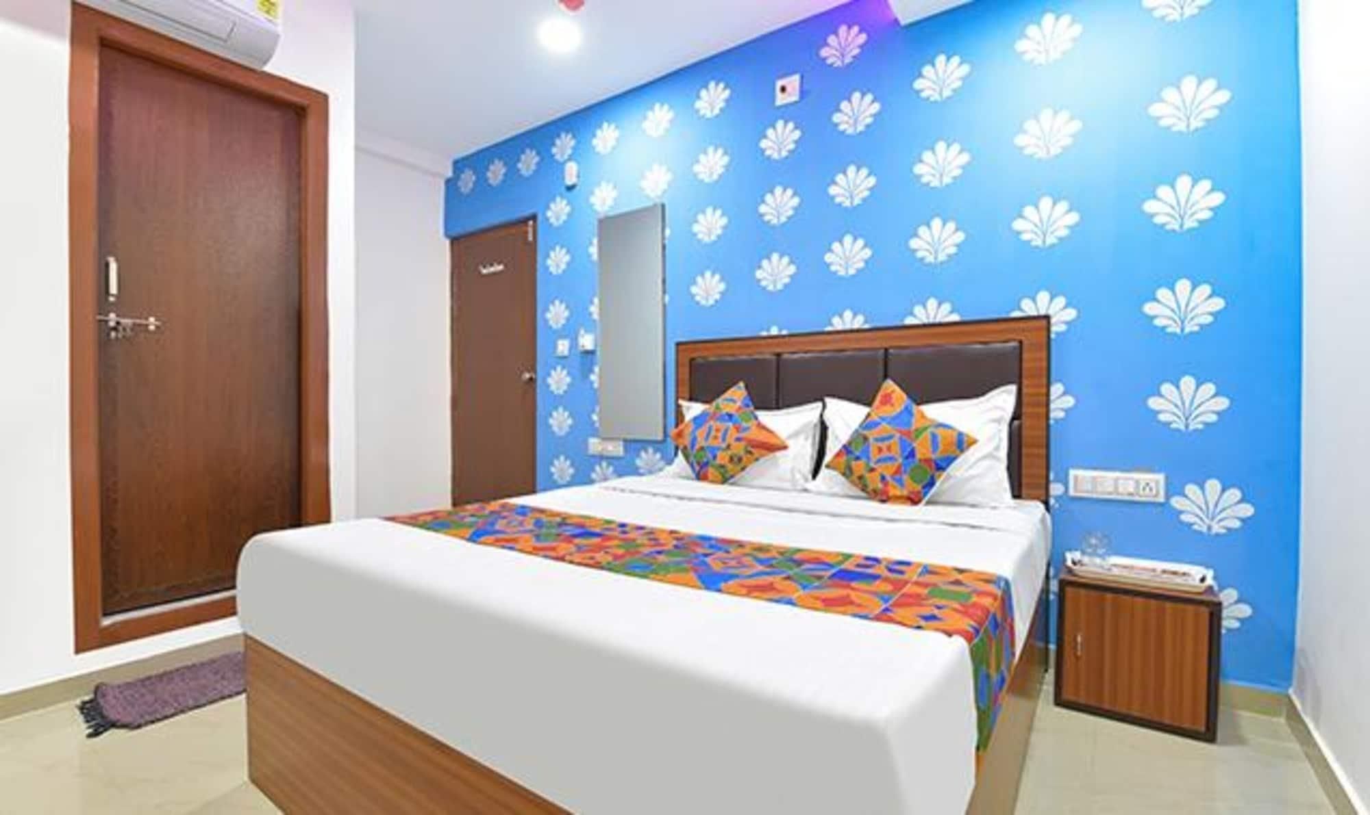 Een slaapkamer met een bed, een houten kledingkast en een deur.
