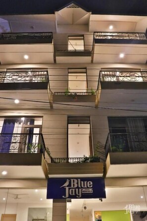 A multi-story building with balconies, a sign for Blue Jay Hostels, and a visible entrance. - The Blue Jay Hostel Rishikesh (Narendranagar)