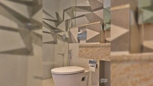 A modern bathroom with a shower, toilet, and a mirror. - The Blue Jay Hostel Rishikesh (Narendranagar)