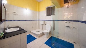 A bathroom with a sink, toilet, and shower area.