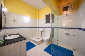 A bathroom with a sink, toilet, and shower area.