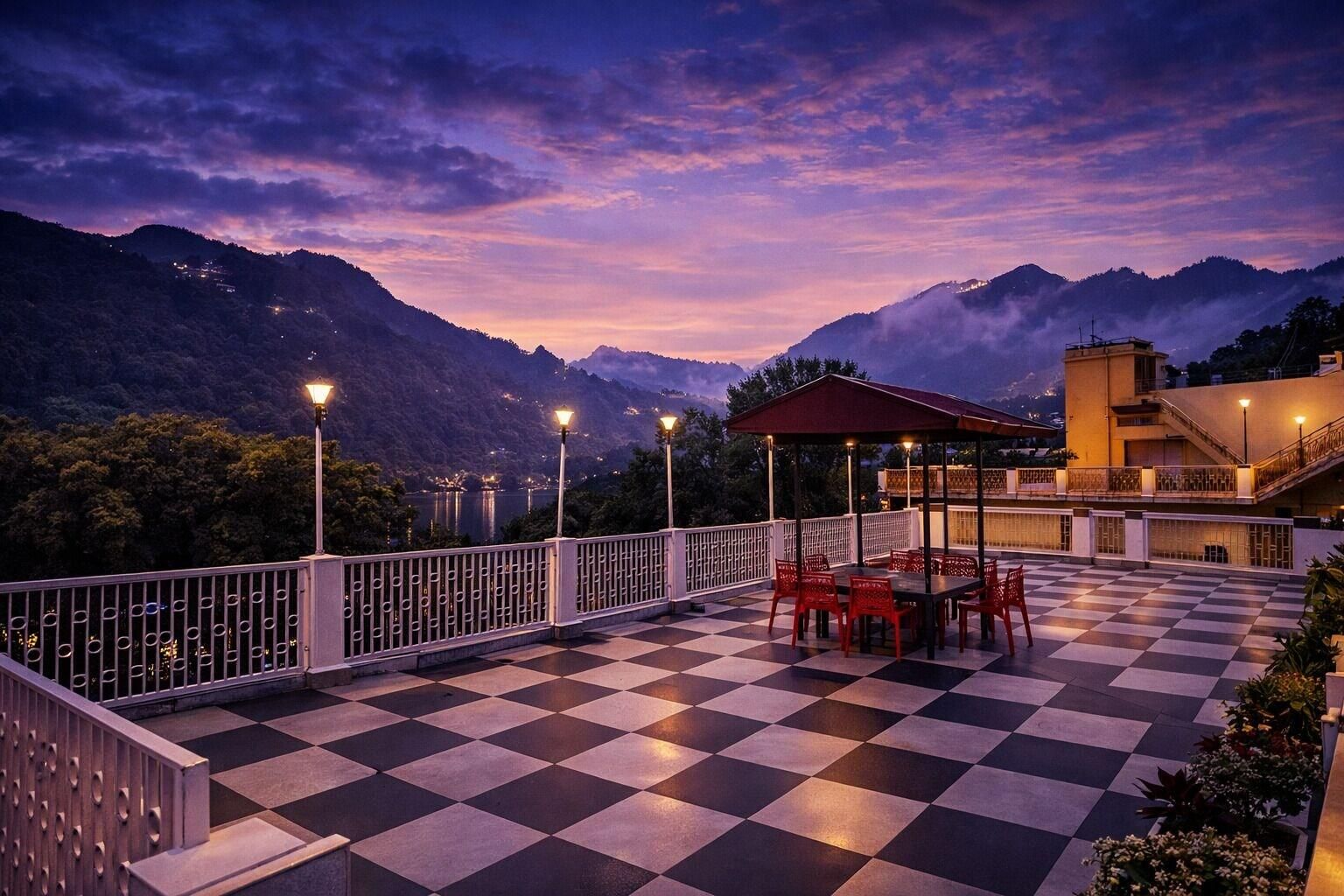 A terrace with a checkered floor, outdoor seating, and a view of mountains.