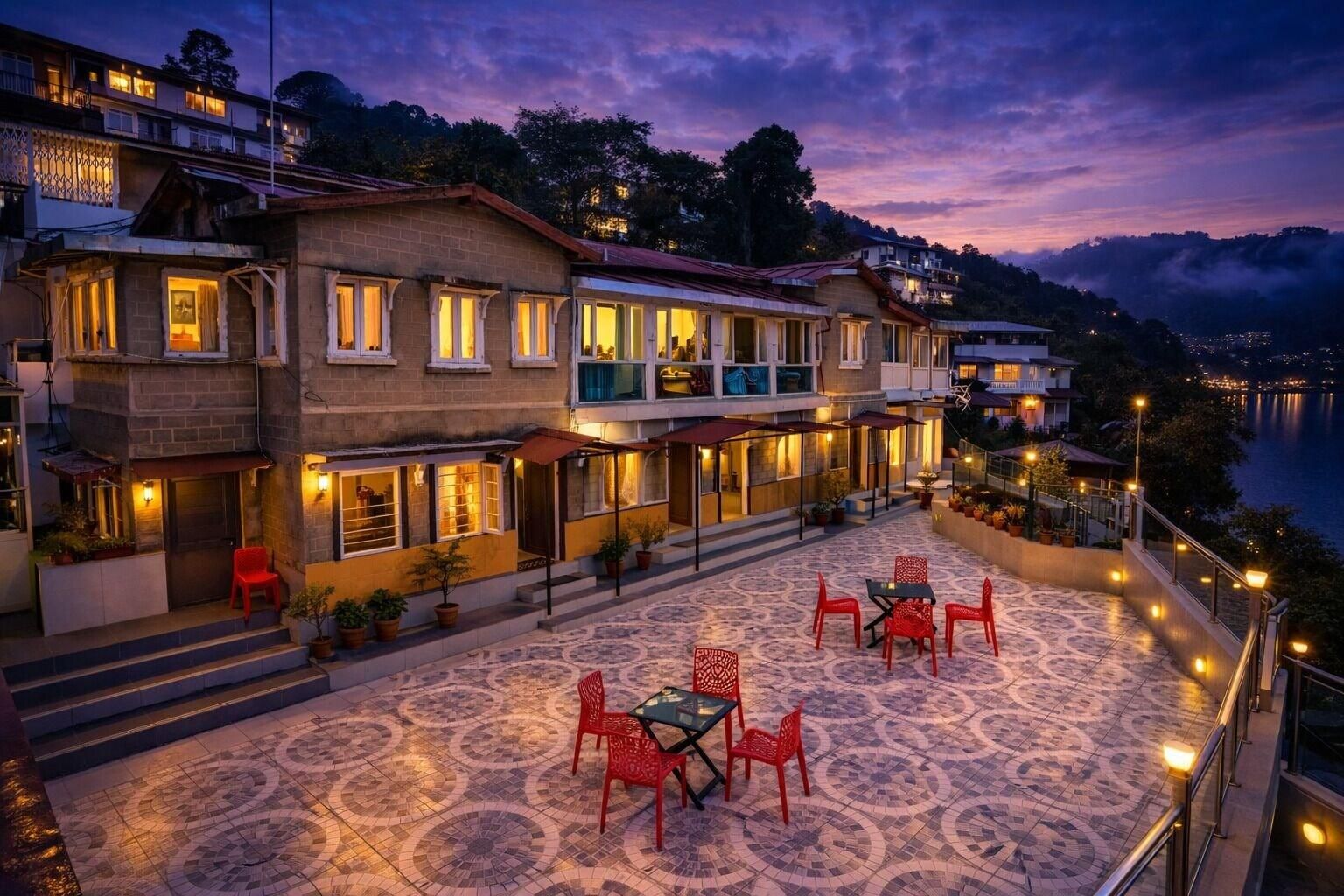 A hotel with a terrace featuring outdoor seating and a view of the water.