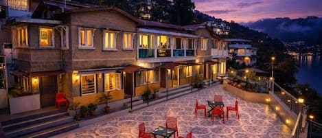 A hotel with a terrace featuring outdoor seating and a view of the water.