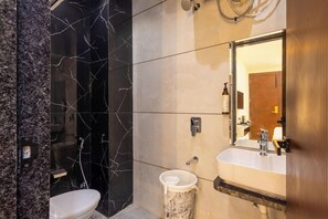 A bathroom with a marble vanity, a toilet, and a shower area. - Hotel Aranyasutra Inaya Indore (Indore)