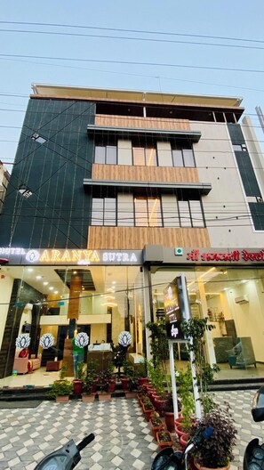 A hotel with a modern facade, a signboard for 'Aranya Sutra,' and a reception area with potted plants. - Hotel Aranyasutra Inaya Indore (Indore)