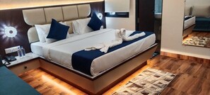 A modern hotel room with a large bed, bedside tables, a nightstand, and a mirror. - Hotel Aranyasutra Inaya Indore (Indore)