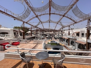 A rooftop terrace with a pool, outdoor seating, and a view of the marina. - El Pacha Suites Sharm Sanafir Hotel (Sharm El Sheikh)