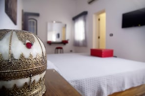 A room with a bed, a mirror, a red box, and a decorative object on a table. - El Pacha Suites Sharm Sanafir Hotel (Sharm El Sheikh)