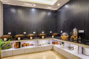 A buffet setup with various food items and utensils on display. - Medalio Boutique Orbit International (Gangtok)