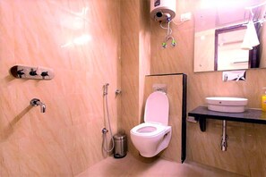 Ein Badezimmer mit Toilette, Waschbecken, Dusche und Spiegel.