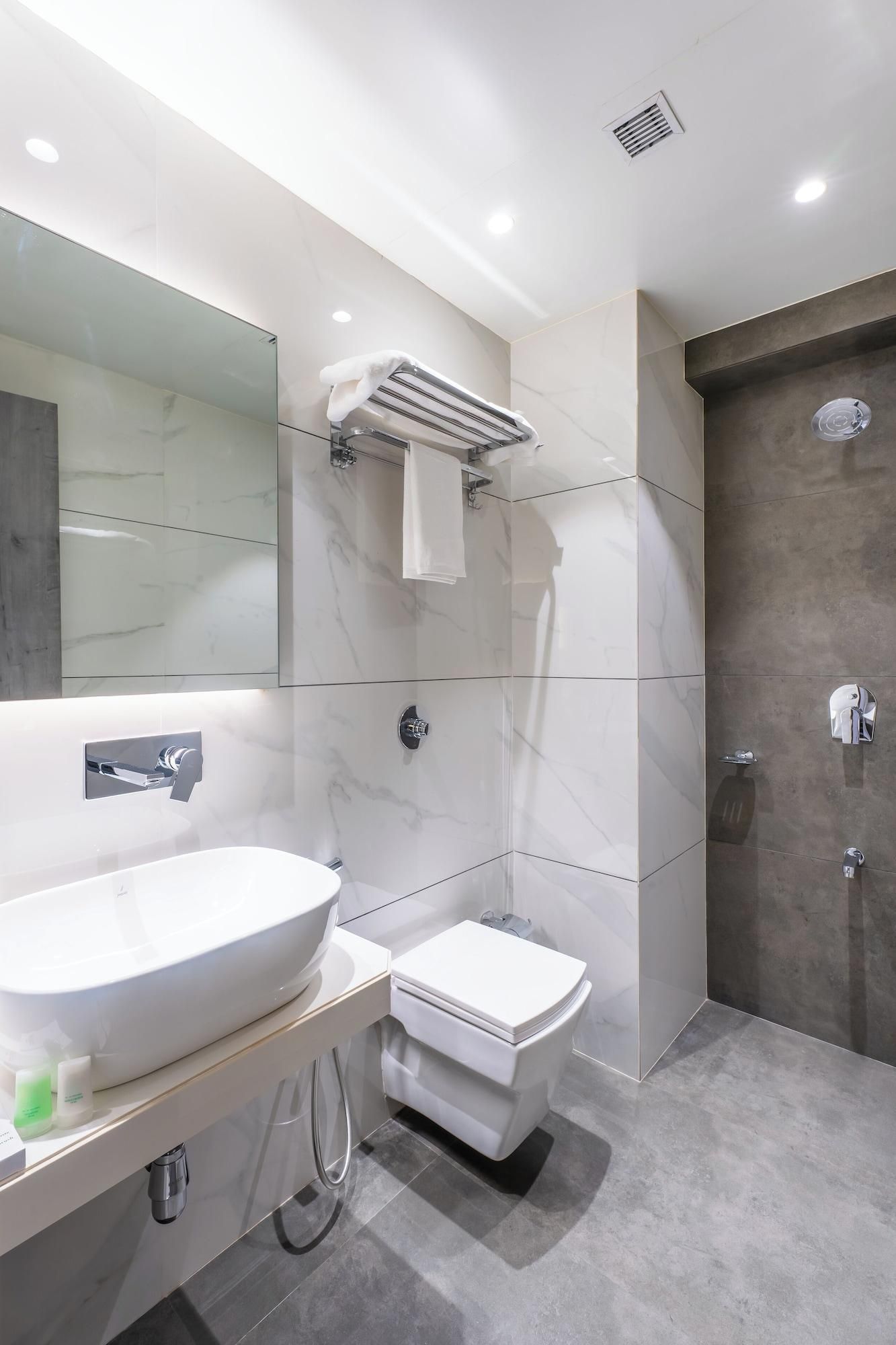 A modern bathroom with a large sink, toilet, and shower.