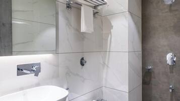 A modern bathroom with a large sink, toilet, and shower.