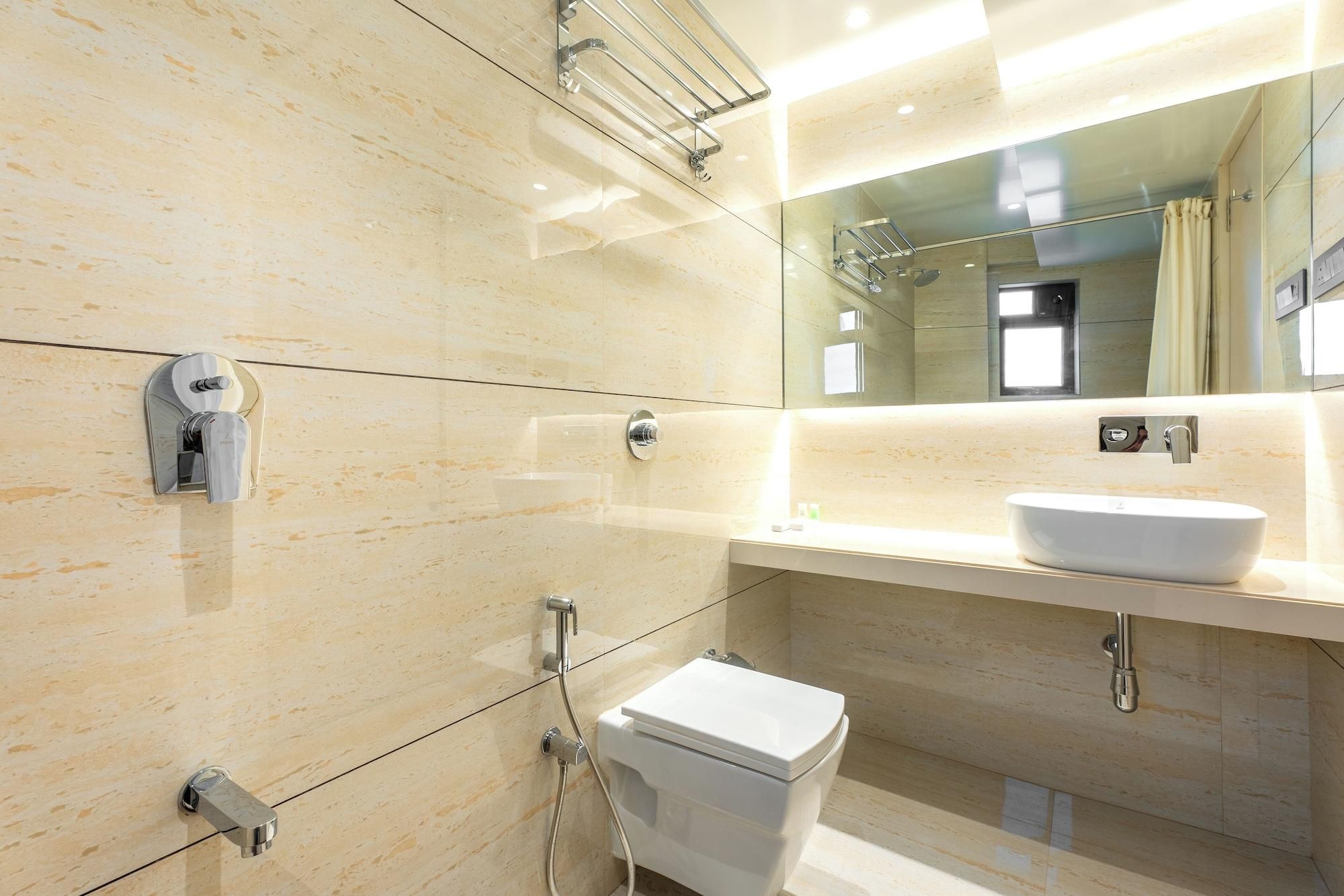 A modern bathroom with a white toilet, a sink, and a shower.