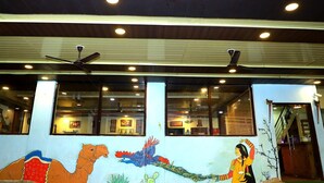 Un edificio con un mural que muestra un pavo real, un camello y una mujer.