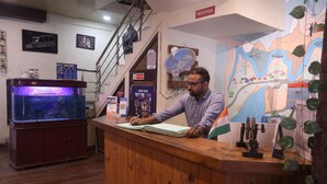 Una recepción con un mapa, un acuario y una escalera.