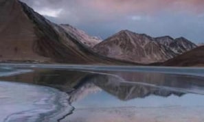 A mountainous landscape with a calm lake reflecting the mountains. - Padma Cottage Pangong (Leh)