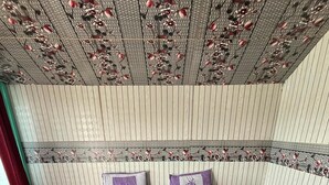 A bed with a patterned bedspread, two pillows, and a decorative ceiling. - Padma Cottage Pangong (Leh)