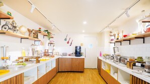Cozinha com armários de madeira, máquina de café e diversos utensílios.