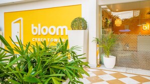 Fachada de loja com um letreiro amarelo que diz 'bloom cyber tower'.